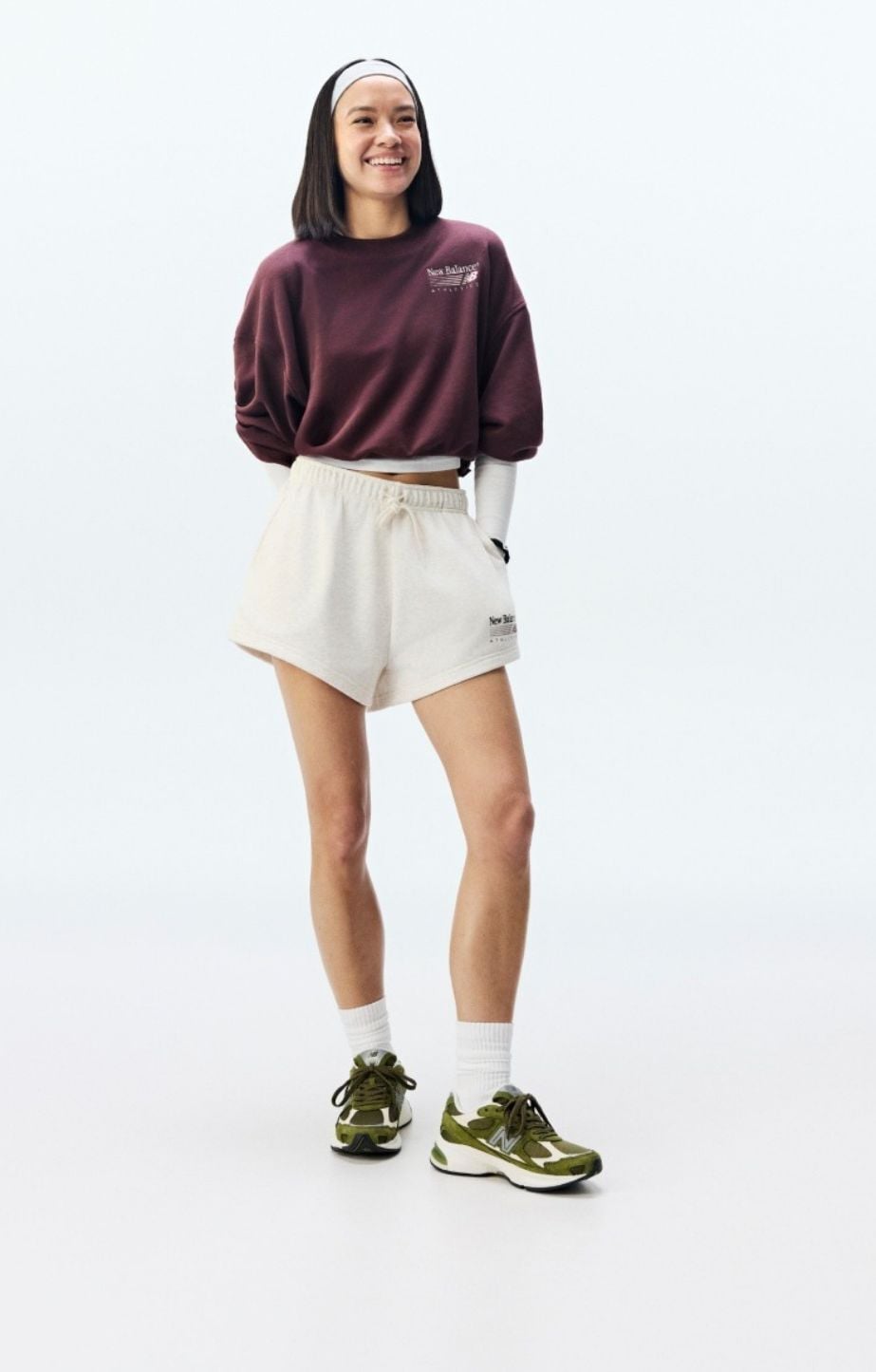 Head to toe shot of a woman wearing a NB tracksuit and Abzorb 5030 shoes. 